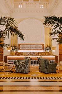 a lobby with two chairs and a table and palm trees at Saint James Paris in Paris