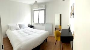 a bedroom with a large white bed and a desk at Superbe 3 PIECES face gare TGV / RER de Massy in Massy