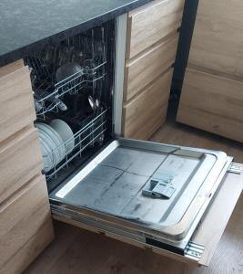 an open dishwasher with its door open in a kitchen at Apartment with Amazing Mountain View in Bolungarvík