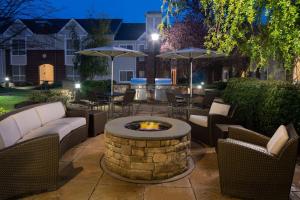 a patio with a fire pit and chairs and umbrellas at Sonesta ES Suites Nashville Brentwood in Brentwood
