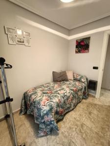 a bedroom with a bed with a floral bedspread at Luxury Family Homes K in Salamanca