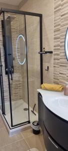 een badkamer met een douche, een wastafel en een bad bij Chambre La Palmeraie village naturiste in Cap d'Agde