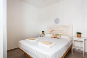 a bedroom with a white bed with two white tables at Caseta Diana - Alcaufar in Sant Lluis