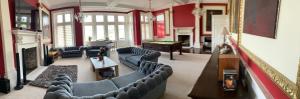 a large living room with couches and a piano at Trawscoed Mansion,Central Wing in Aberystwyth