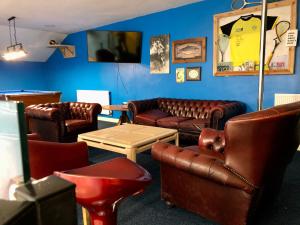 a living room with leather couches and a table at Woolston lodge in Oswestry