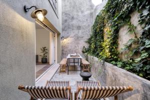 a patio with two chairs and a table and a wall with plants at Victoria XV in Cascais