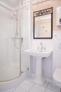 uma casa de banho branca com um lavatório e um chuveiro em Step8_18 em Westerland