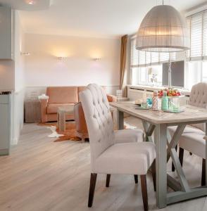 eine Küche und ein Wohnzimmer mit Tisch und Stühlen in der Unterkunft Ad3 5F Luxury West in Westerland