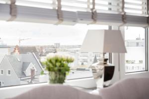 ein Tisch mit einer Lampe und einer Vase mit Blumen in einem Fenster in der Unterkunft Ad3 5F Luxury West in Westerland + 16 Fotos