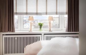 ein Schlafzimmer mit einem Bett und zwei Lampen im Fenster in der Unterkunft Ad3 5F Luxury West in Westerland
