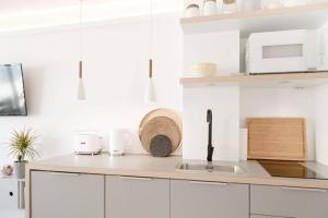 uma cozinha branca com armários brancos e um lavatório em F 41_ App_ 401 em Westerland