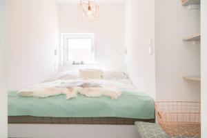 uma cama num quarto branco com uma janela em F 41_ App_ 401 em Westerland