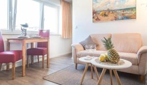 ein Wohnzimmer mit einem Sofa und einem Tisch mit Ananas in der Unterkunft AD1 _ 203 Boardrider_s in Westerland