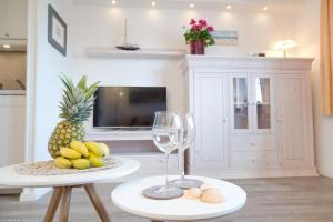 eine Küche mit einem Tisch mit Ananas und einem Glas Wein in der Unterkunft AD1 _ 203 Boardrider_s in Westerland