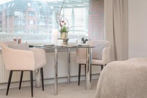un tavolo da pranzo con sedie bianche e una finestra di Bommi7 a Westerland