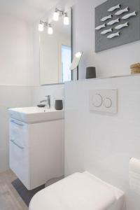Baño blanco con aseo y lavamanos en Theodor _ AD 1_ App_ 407, en Westerland