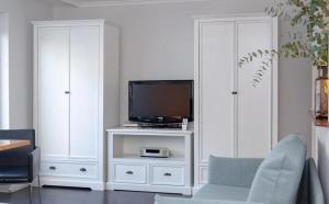 - un salon avec une télévision et une armoire blanche dans l'établissement Ad5 408 Dwarsloeper 3, à Westerland