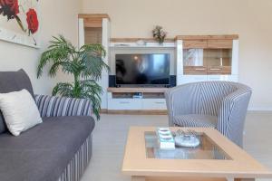 uma sala de estar com um sofá e uma mesa de centro em Haus Lia Links App 3 em Tinnum