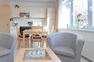 uma cozinha e sala de jantar com mesa e cadeiras em Haus Lia Links App 3 em Tinnum