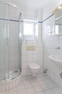 uma casa de banho branca com um WC e um lavatório em Haus Lia Links App 3 em Tinnum