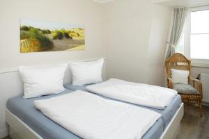 1 Schlafzimmer mit 2 Betten und einem Stuhl in der Unterkunft Big Wave (Vik1 - 24) in Westerland