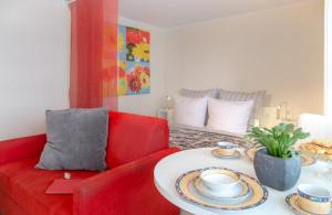 ヴェスターラントにあるAd5 305 Dwarsloeper 1のリビングルーム(赤いソファ、テーブル付)