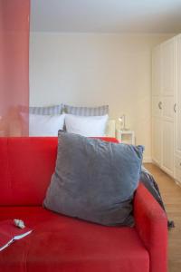 a red couch with a gray pillow on top of it at Ad5 305 Dwarsloeper 1 in Westerland (Sylt)