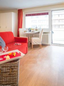 Ad5 305 Dwarsloeper 1 في فيسترلاند: غرفة معيشة مع أريكة حمراء وطاولة