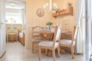 een eetkamer met een tafel en stoelen en een klok bij Bom5_1 in Westerland