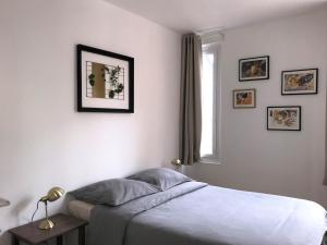 Habitación blanca con cama y ventana en Appartements Maisons Bleues, en Honfleur