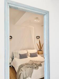 a bedroom with a white bed and a mirror at Villa Elenia in Tsoukalades