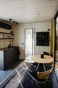 eine Küche mit einem Holztisch und Stühlen im Zimmer in der Unterkunft ÖÖD Hötels Laheranna SUDU- with sauna in Punakivi