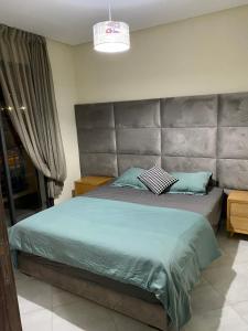 a bedroom with a large bed with a large headboard at Oceanica by Smir Park luxury apartment Marina Smir in M'diq