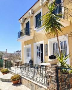 ein Haus mit einer Palme davor in der Unterkunft Hotel Aegina in Ägina Stadt