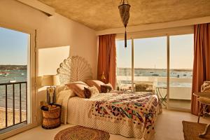 a bedroom with a bed with a view of the ocean at FORMENTERA WHITE ESTUDIOS in La Savina