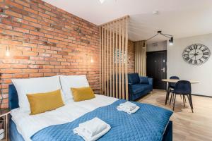 a bedroom with a brick wall and a bed at Rent like home - Dwie Motławy in Gdańsk