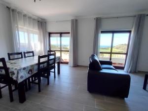 a dining room with a table and chairs and windows at Residencias Ana Carmen in Viana do Castelo