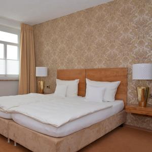 ein Schlafzimmer mit einem großen Bett mit weißen Kissen in der Unterkunft Rieslinghaus Bernkastel (ehm.Weinhaus Porn) in Bernkastel-Kues