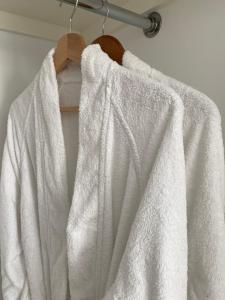 a white robe is hanging on a hanger at Seaglass Cottage, 5 mins from beach, leafy lane, hot tub in South Hayling