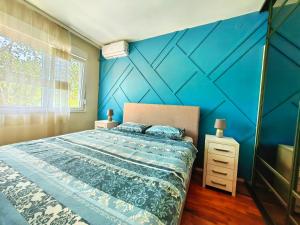 a bedroom with a blue accent wall and a bed at Luxury apartment Podgorica in Podgorica