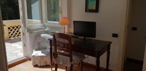 a desk with a television and a chair in a room at VILLA MARE BLU in Levanto