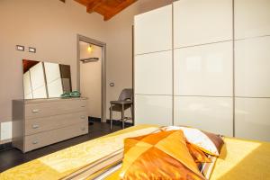 a bedroom with a bed and a dresser and a mirror at Casa a schiera Budoni in Budoni