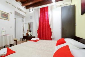 a bedroom with a large bed and a red curtain at Apartment City Center Dragica in Zadar