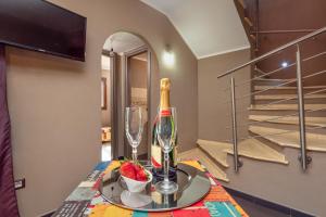 a table with a bottle of wine and a glass at Casa a schiera Budoni in Budoni +17 photos