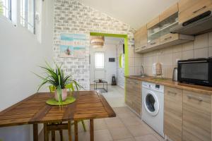 a kitchen with a wooden table and a washing machine at GK Home I part of Gk Fitness Club in Faliraki