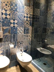 y baño con lavabo, aseo y azulejos. en Affittacamere Joss, en La Spezia