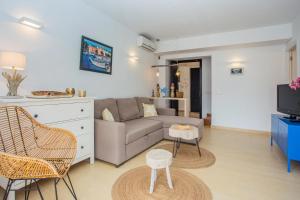 un soggiorno con divano e TV di Menorca Blue a Cala Santandria