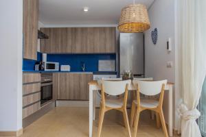 uma cozinha e sala de jantar com mesa e cadeiras em Menorca Blue em Cala Santandria