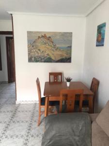 mesa de comedor y sillas con una pintura en la pared en Apartamento de verano 1 habitación, en Ajo