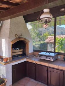 a kitchen with a brick oven with a window at villa de charme in Monoblet